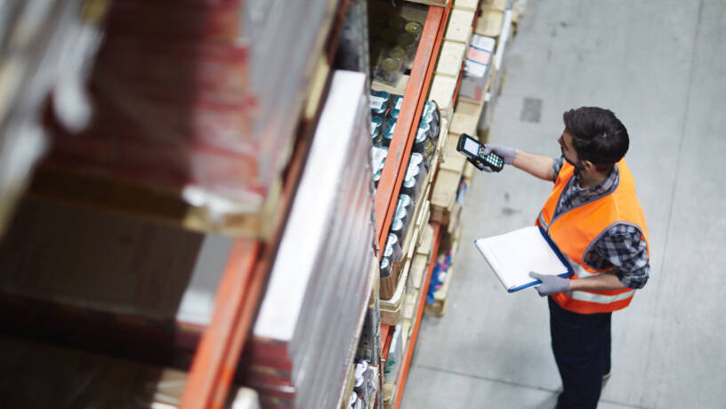 Warehouse employee working in warehouse while wearing a high-vis vest