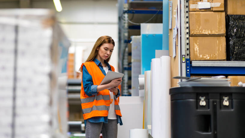 Woman in high-vis vest working in warehouse